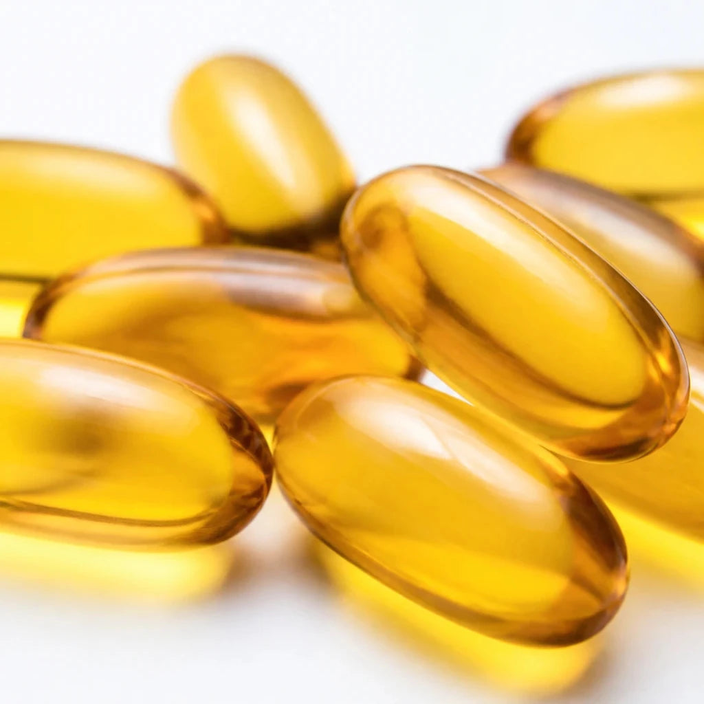 Close-up of golden Mainstream CBD 25mg full spectrum gel capsules, 20mg CBD + 5mg CBG softgels